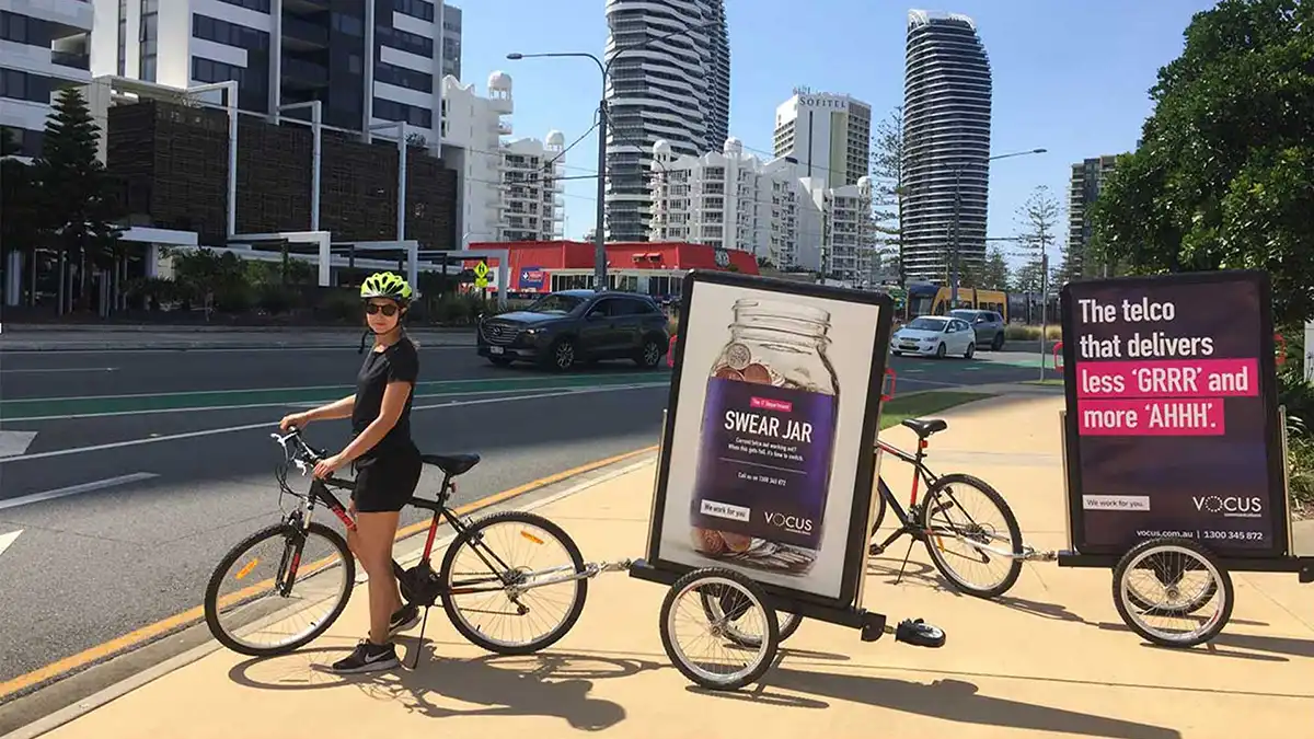 Bike board activator promoting brand message in busy city street.